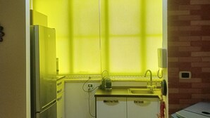 Eine kleine Küche mit Kühlschrank, Spüle und Arbeitsplatte.