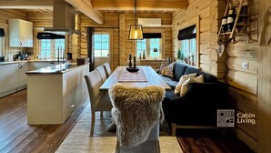 A cabin interior with a dining area, kitchen, and living space. - Stylish log cabin in Hafjell w/view & sauna (Øyer kommune)