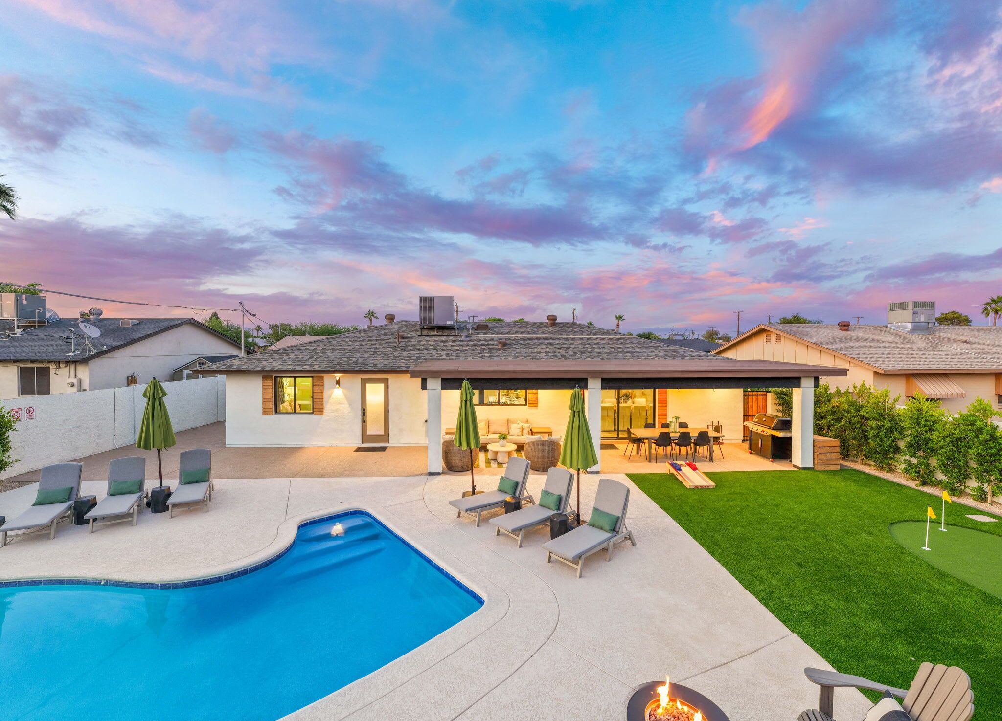 Une maison moderne dotée d’une piscine, d’un espace salon extérieur et d’un patio.