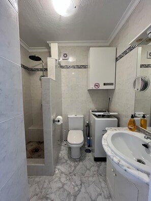 A bathroom with a toilet, shower, sink, and a mirror. - Studio in Torrox Costa, 2 minutes walk from the beach and the promenade (Torrox Costa)