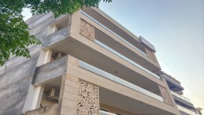 A multi-story building with balconies and decorative panels. - Housr 1 RK Sector 27 Gurgaon Golf Course (Gurugram)