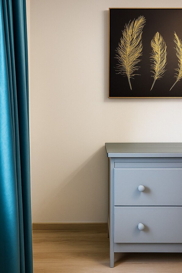 Una habitación con un armario azul claro, una pared color beige y una obra enmarcada con espigas doradas.