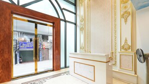 A reception area with a marble floor, a reception desk, and a glass door leading to the outside. - NINE HOUSING 68 Kim Ma Thuong (Hanoi)