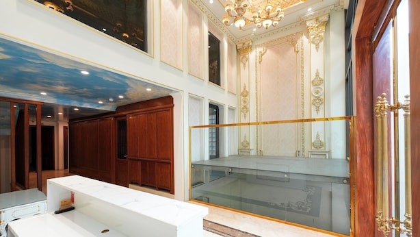 A luxurious interior with a marble floor, a white reception desk, wooden cabinets, and a glass railing overlooking a balcony. - NINE HOUSING 68 Kim Ma Thuong (Hanoi)