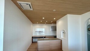 Cozinha moderna com ilha central, iluminação embutida e coifa integrada.