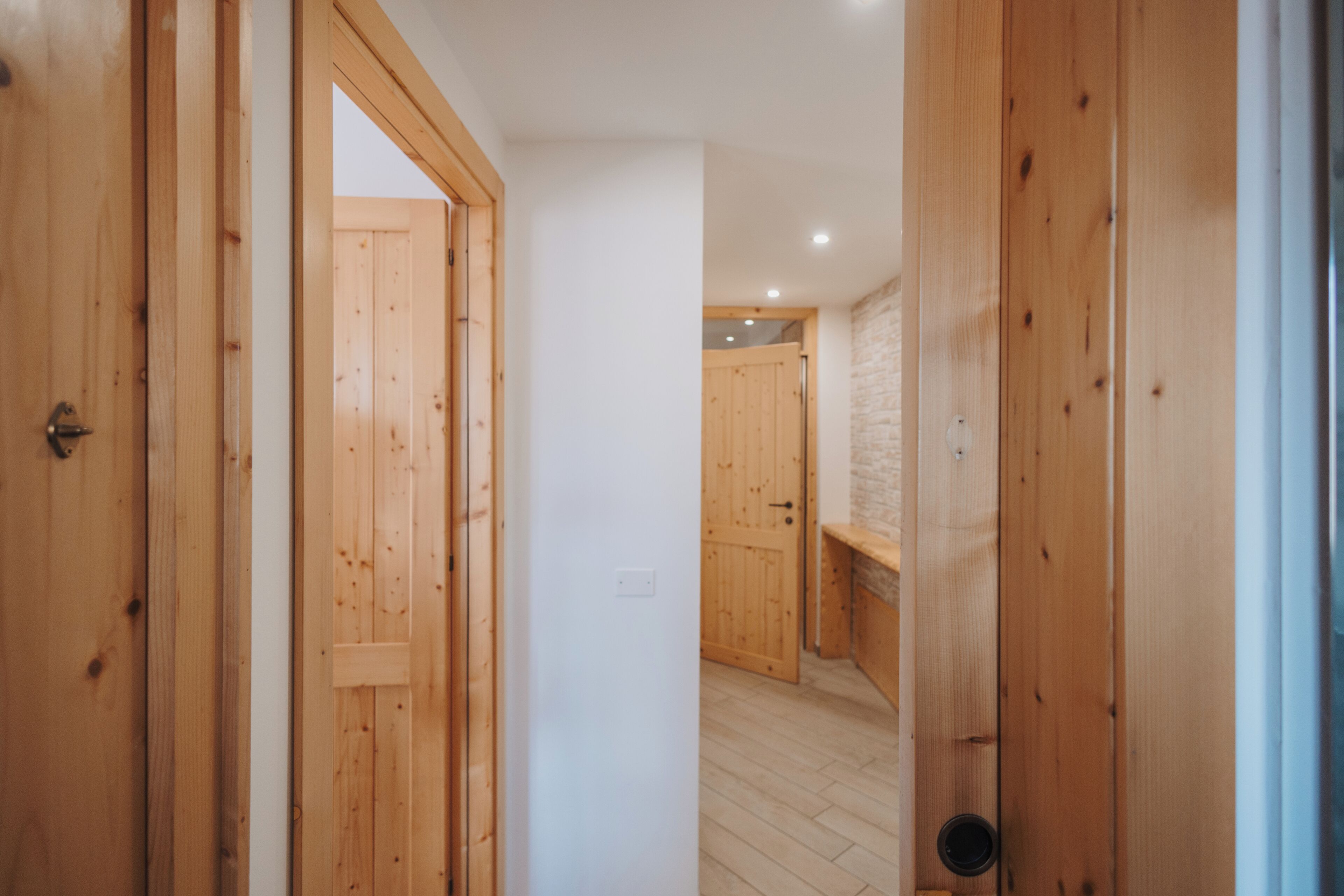 Ein mit Holz verkleidter Innenbereich mit einem zur Kammer führenden Durchgang.