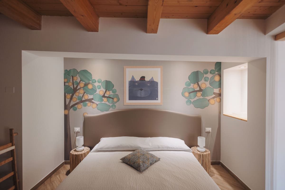 A bedroom with a large bed, wooden headboard, and two bedside tables with lamps.