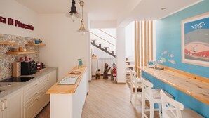 Une cuisine moderne avec un îlot central en bois, des armoires blanches et un mur d’accent bleu.