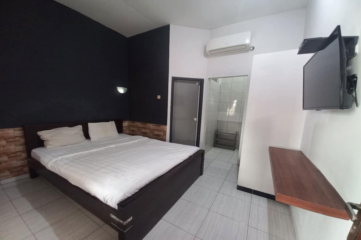 Ein Schlafzimmer mit einem Bett, einem Fernseher und einer Klimaanlage.
