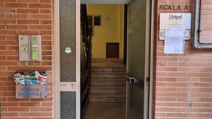 Une entrée d’immeuble avec une façade en briques, une porte en métal, un escalier menant à l’intérieur et une enseigne « Unipol » sur le côté droit.