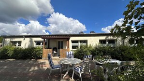 A building with a covered patio area, outdoor seating, and a view of the sky. - Modern Holiday Home with Garden and nature near Warnow (Warnow)