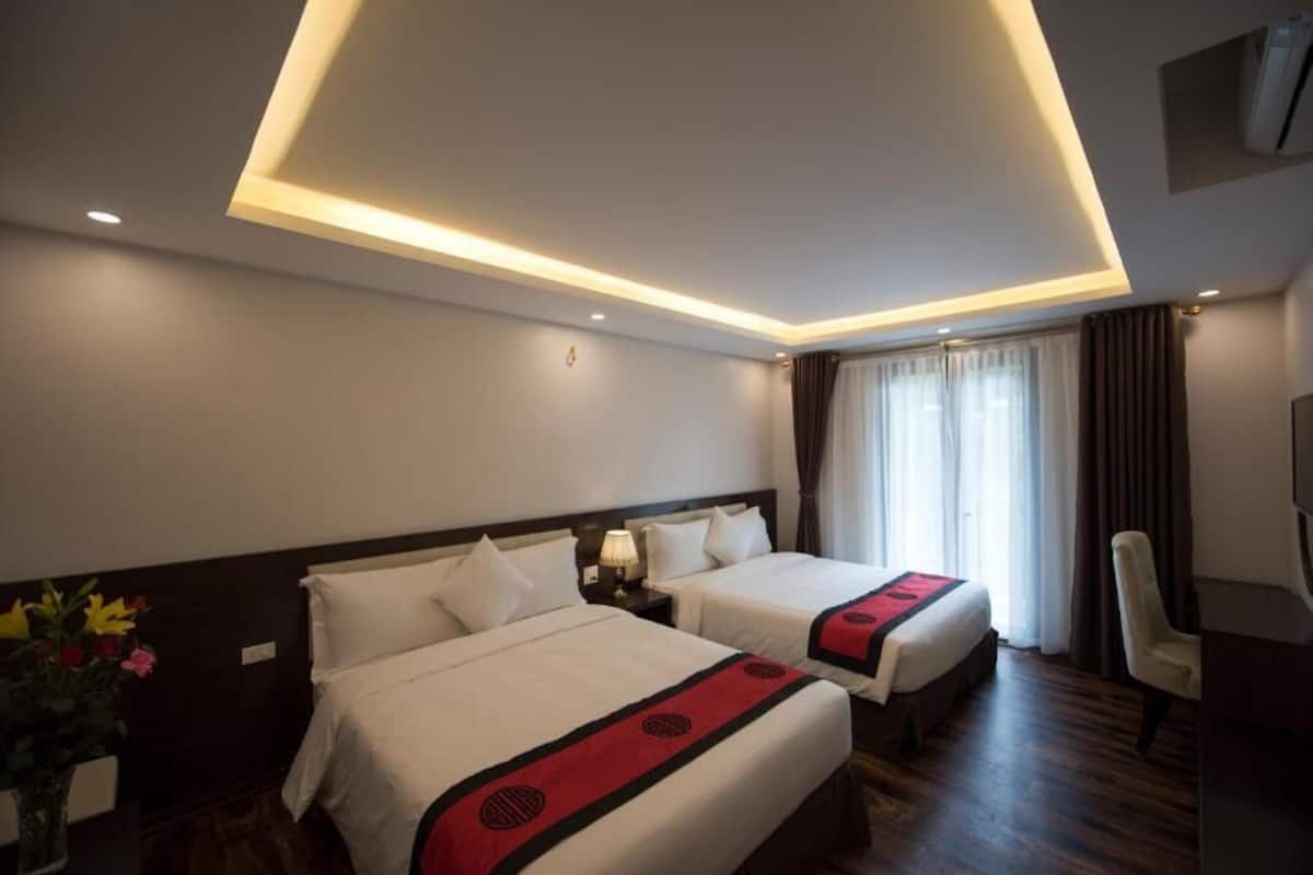 Een hotelkamer met twee bedden, een bureau en een stoel.