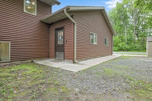 Une maison à deux étages, avec une façade marron, une porte d’entrée et un petit porche.