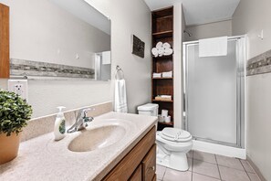 Une salle de bain moderne équipée d’un lavabo, de toilettes et d’une douche.