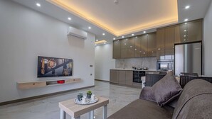 A modern living room with a flat-screen TV, a wooden coffee table, and a sofa.