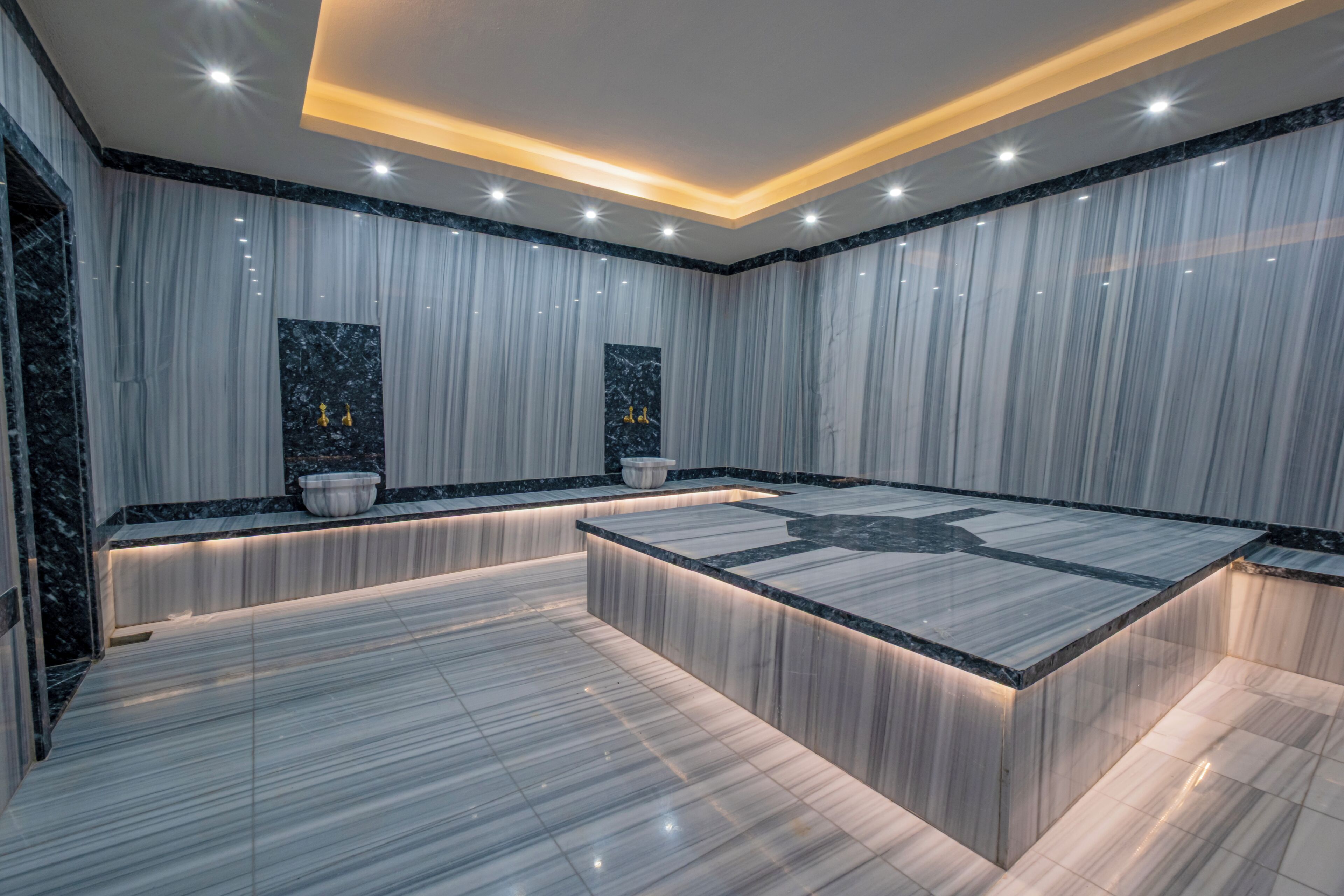 A modern bathroom with marble flooring, a central island, and a large mirror.