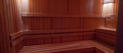 A wooden sauna with benches and a wooden ceiling.
