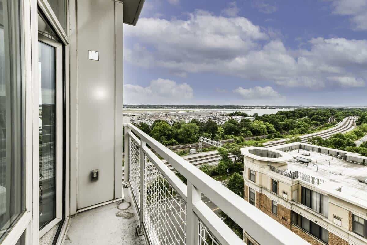 Un balcon offrant une vue sur le paysage urbain, avec ses rues et ses espaces verts.