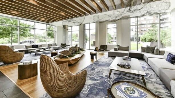 A spacious living area with large windows, a wooden ceiling, and modern furniture. - Stylish 2BR Stay with Gym, Parking & Rooftop Views (Arlington)