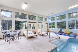 Un espace piscine comprenant un jacuzzi, des chaises longues et une table avec des chaises.