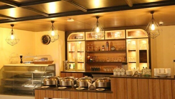 Un espace buffet doté d’une vitrine, d’un comptoir en bois et d’un éclairage suspendu.