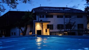 Un edificio con piscina al anochecer.