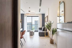 Uma sala de estar moderna com um sofá, uma poltrona, uma mesa de centro e um vaso com planta.