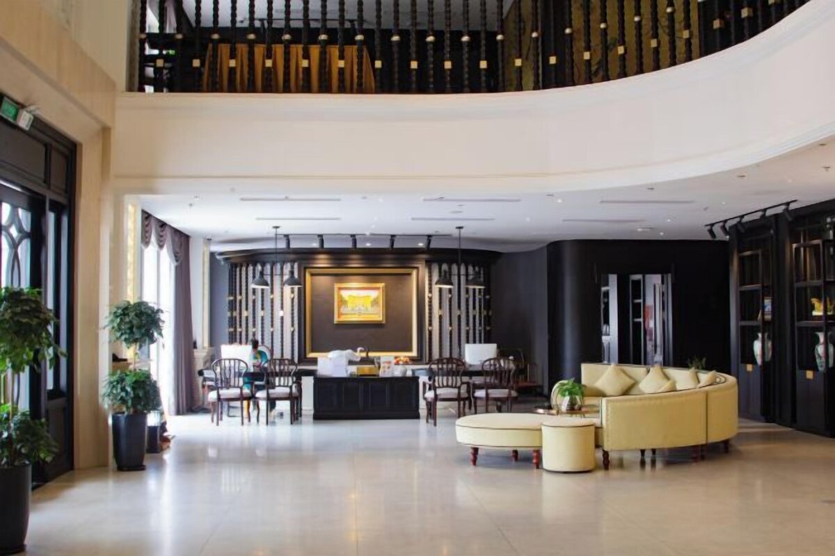A spacious lobby with a reception desk, seating area, and a curved sofa.