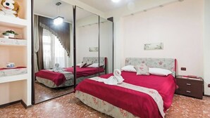 Een hotelkamer met een groot bed, een nachtkastje, een spiegel en een garderobe.