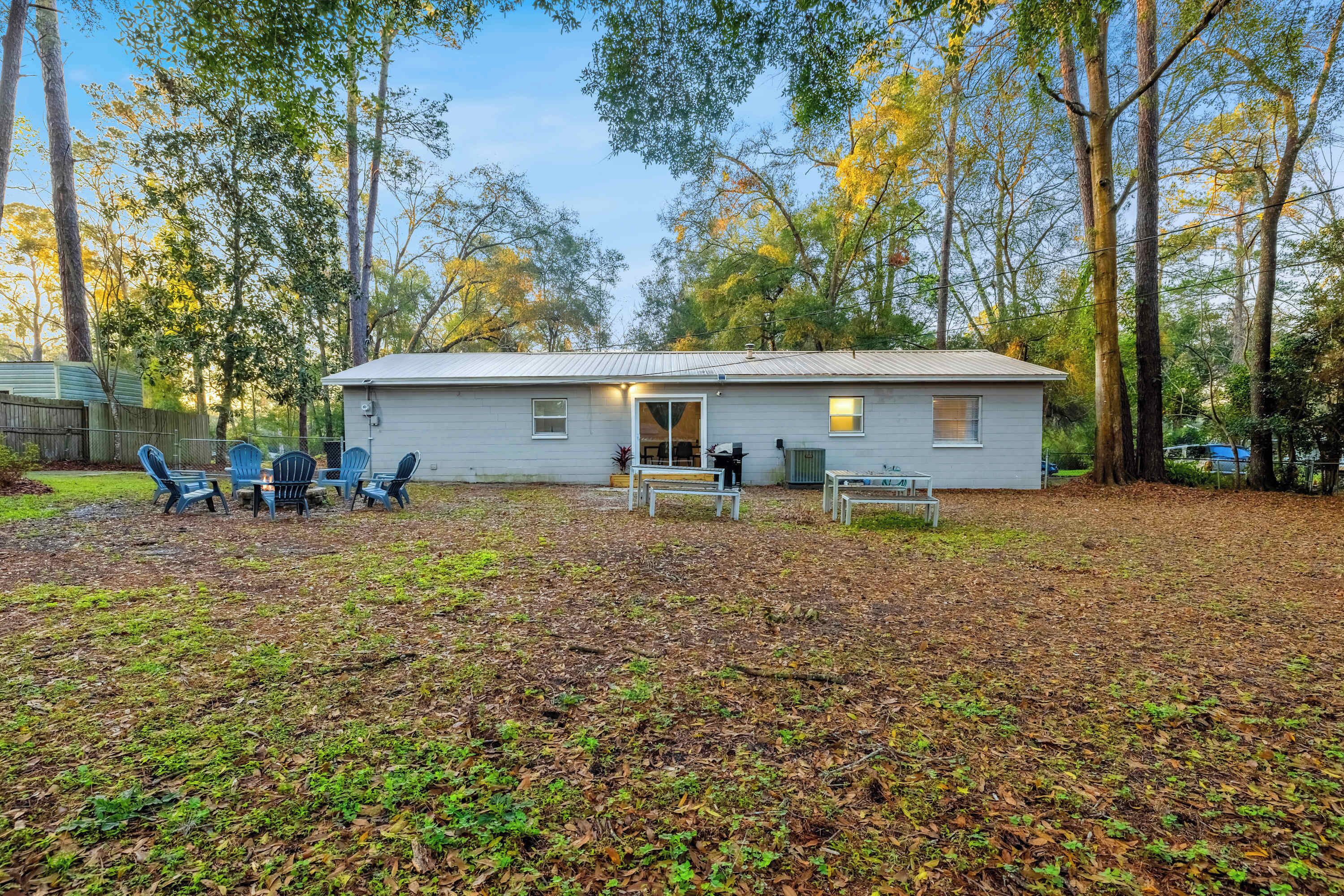 A single-story house with a front porch, a small deck, and a backyard with a patio area.