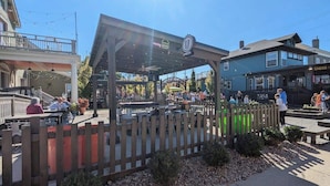 An outdoor seating area with a wooden fence, tables, and chairs. - Riverview Retreat Only 1 Mi Downtown Louisville! (Jeffersonville)