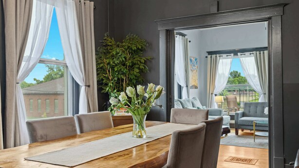 A dining area with a wooden table, chairs, and a vase of flowers. - Walkable Historic District 1 Mi to Downtown Lou! (Jeffersonville)