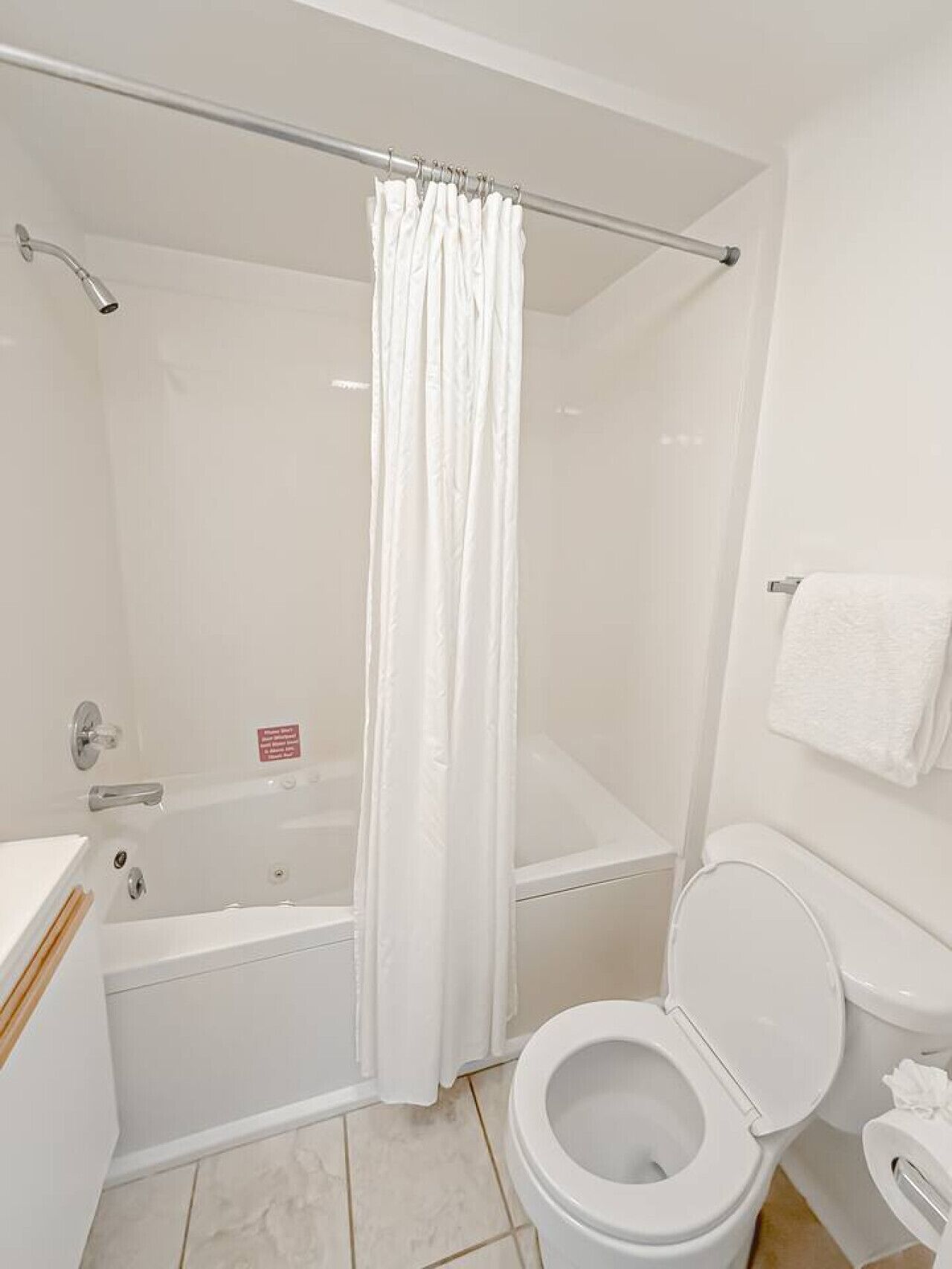 A bathroom with a bathtub, toilet, and shower curtain.