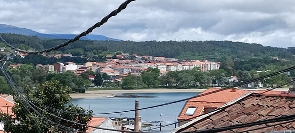 Un pueblo costero con edificios, una playa y una masa de agua.