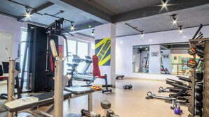 A gym with various exercise equipment, including a bench press, dumbbells, and a treadmill. - Housr Sector 69 Gurgaon Near Sohna Road (Gurugram)