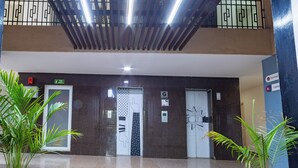A lobby with a staircase, elevator, and a fire safety sign. - Housr Sector 69 Gurgaon Near Sohna Road (Gurugram)