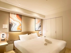 A hotel room with a large bed, a nightstand, and a wardrobe. - JStar Hotel Shinsaibashi (Osaka)