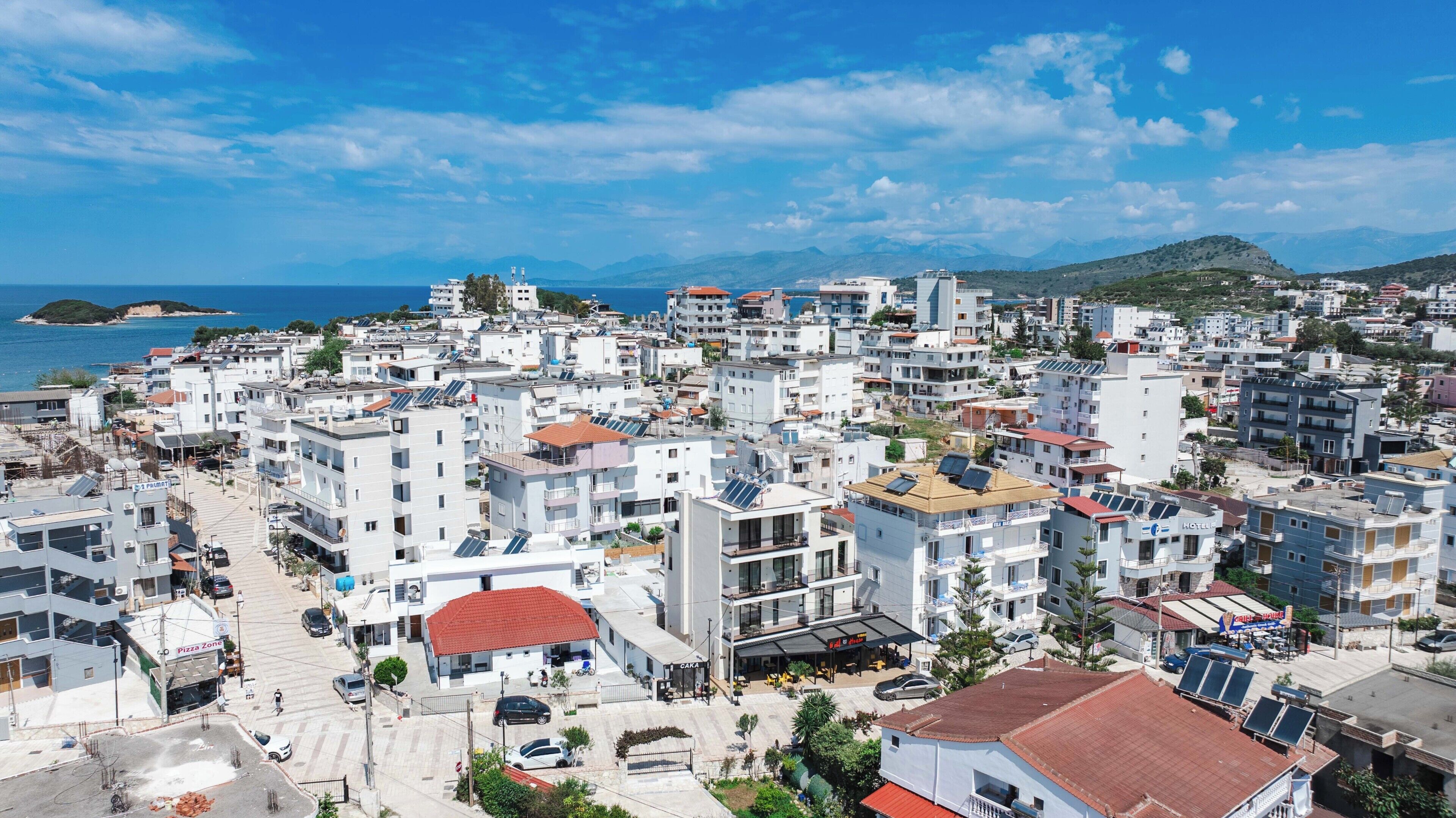 A coastal town with a mix of residential and commercial buildings, including a visible pizza restaurant.