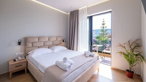 Habitación de hotel moderna con una cama grande, una mesita de noche con teléfono, una planta en maceta y vistas a la ciudad.