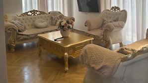 Una sala de estar con dos sofás, una mesa de centro y un televisor.