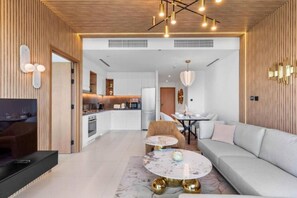 En moderne stue med sofa, sofabord og spiseplads med bord og stole.