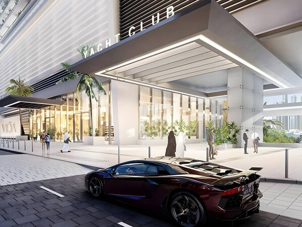 A modern building with a sign reading 'YACHT CLUB' and a luxury car parked in front.