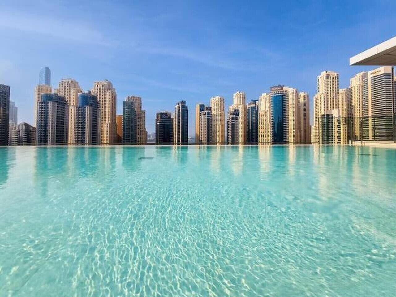 A swimming pool with a city skyline in the background.