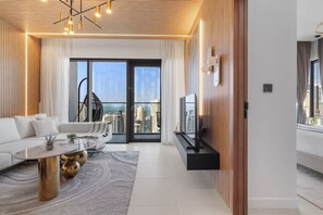 A modern living room with a sofa, coffee table, and a flat-screen TV.