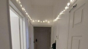 Ein Flur mit weißen Wänden, Teppichboden und einer Tür rechts.