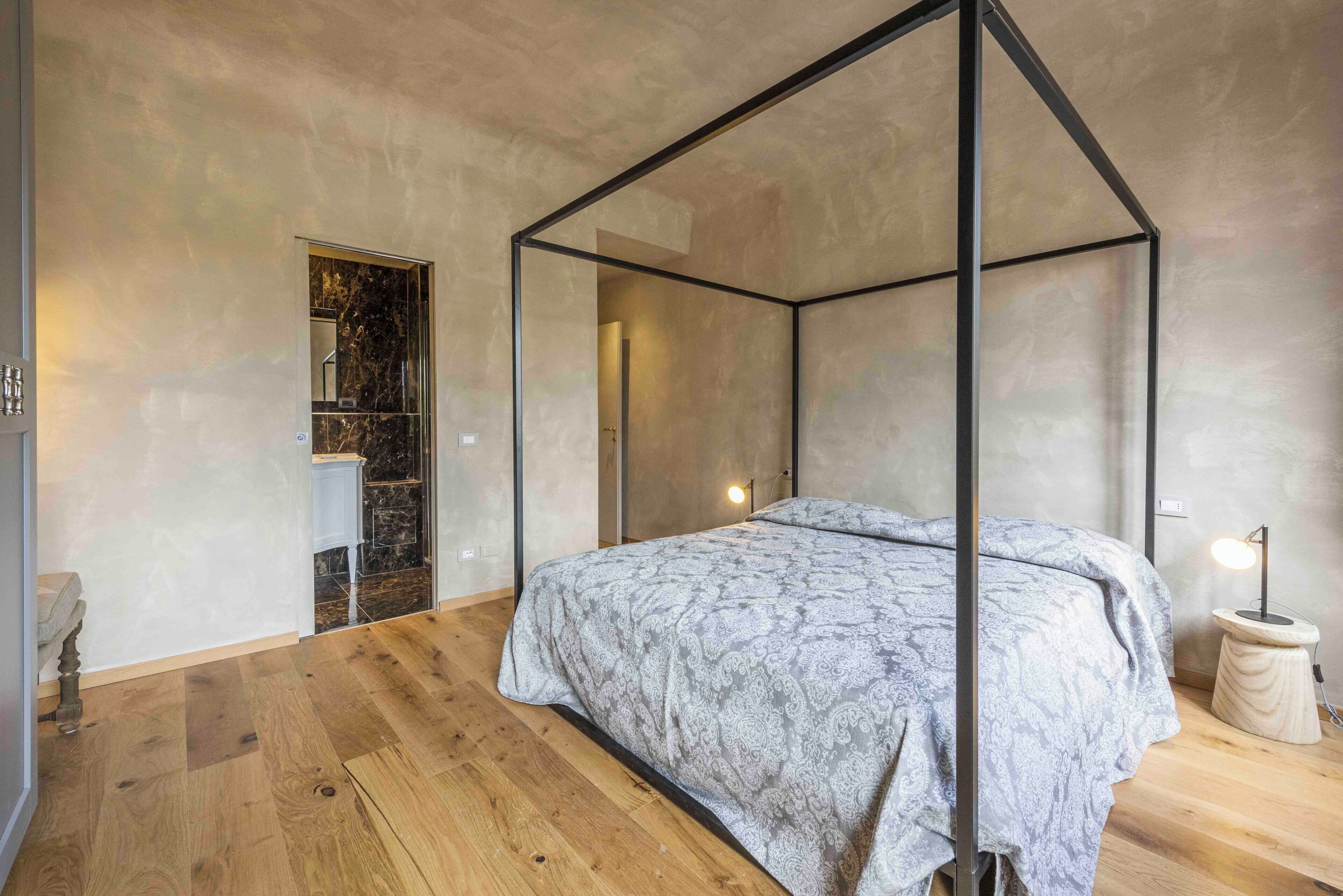 Un dormitorio con cama con dosel, suelo de madera y diseño moderno.