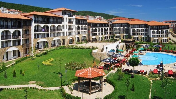 Un hôtel comprenant plusieurs bâtiments, une piscine et un jardin bien entretenu.