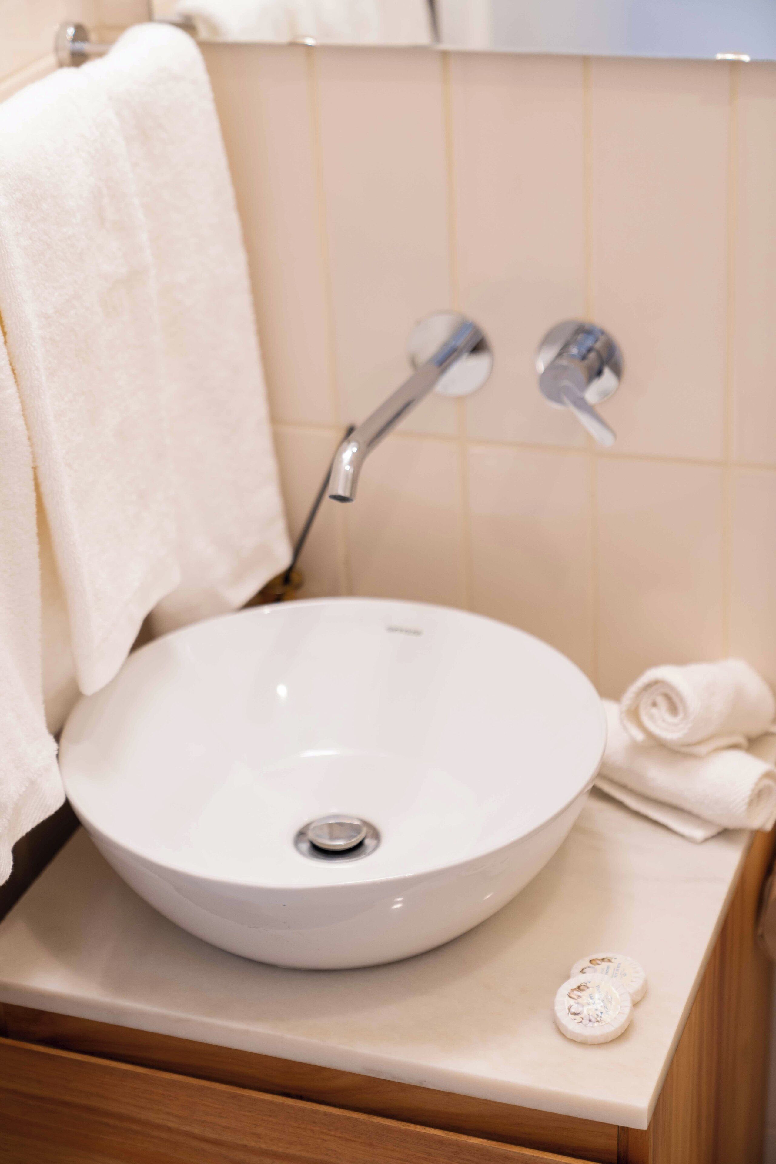 A bathroom with a white sink, a towel, and a soap dish.