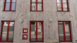 Un edificio con varias ventanas, algunas con marcos rojos y otras con marcos blancos.