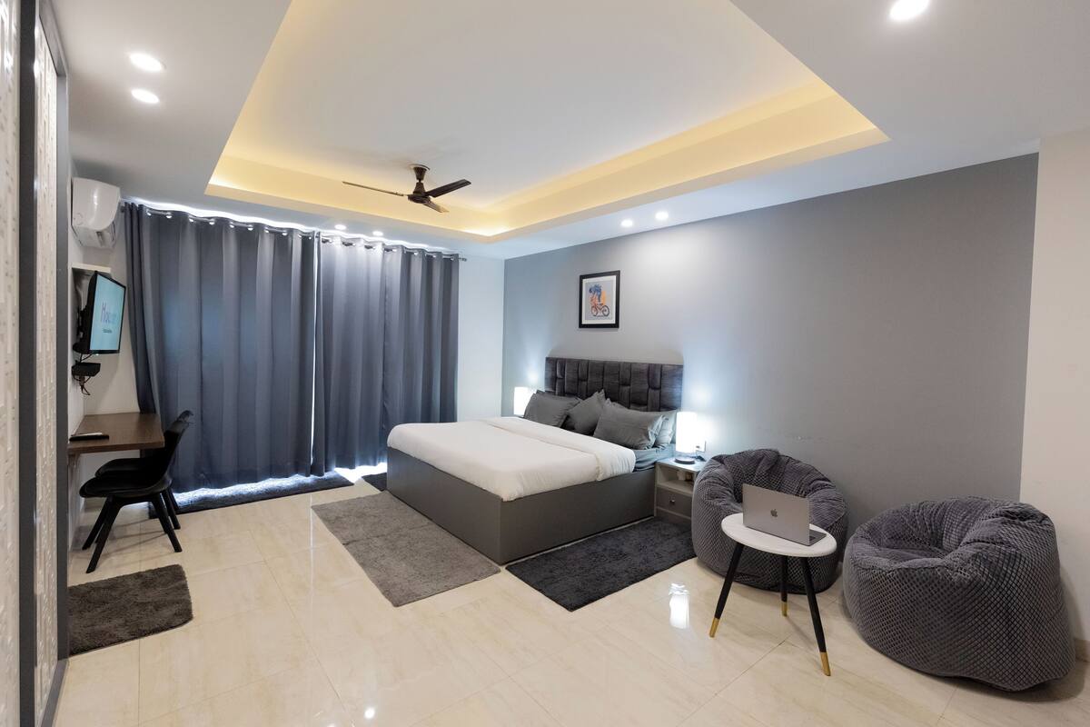 Ein modernes Schlafzimmer mit Bett, Schreibtisch, Stuhl und zwei Sitzsäcken.